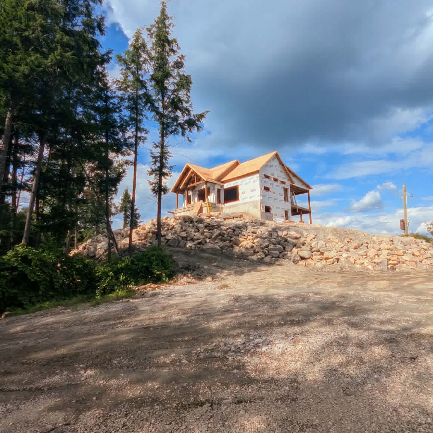 Maison en construction sur un site boisé et rocheux